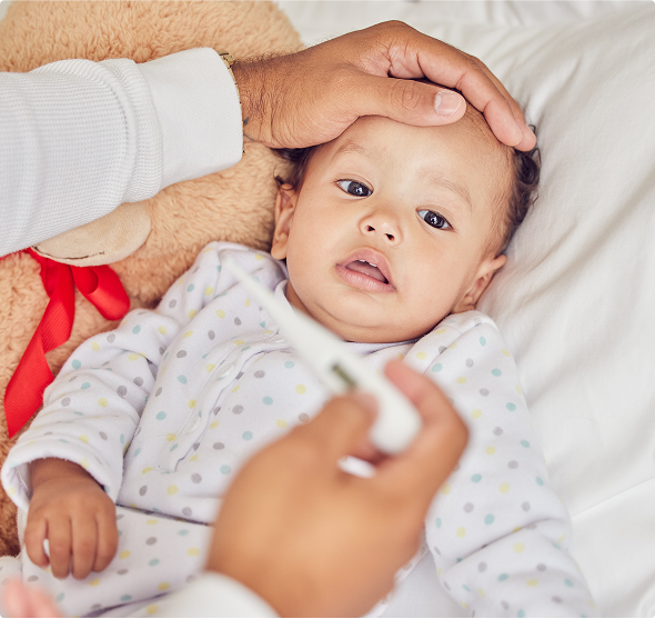 Un parent prend la température d’un enfant présentant des symptômes de méningite à méningocoques Un parent prend la température d’un enfant présentant des symptômes de méningite à méningocoques